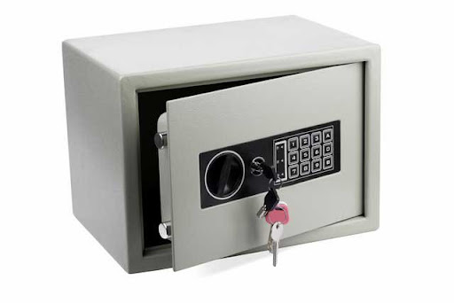 A small home safe with an electric combination lock and a key.