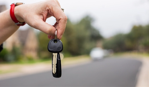 A close up of a person’s hands holding a pair of keys. 