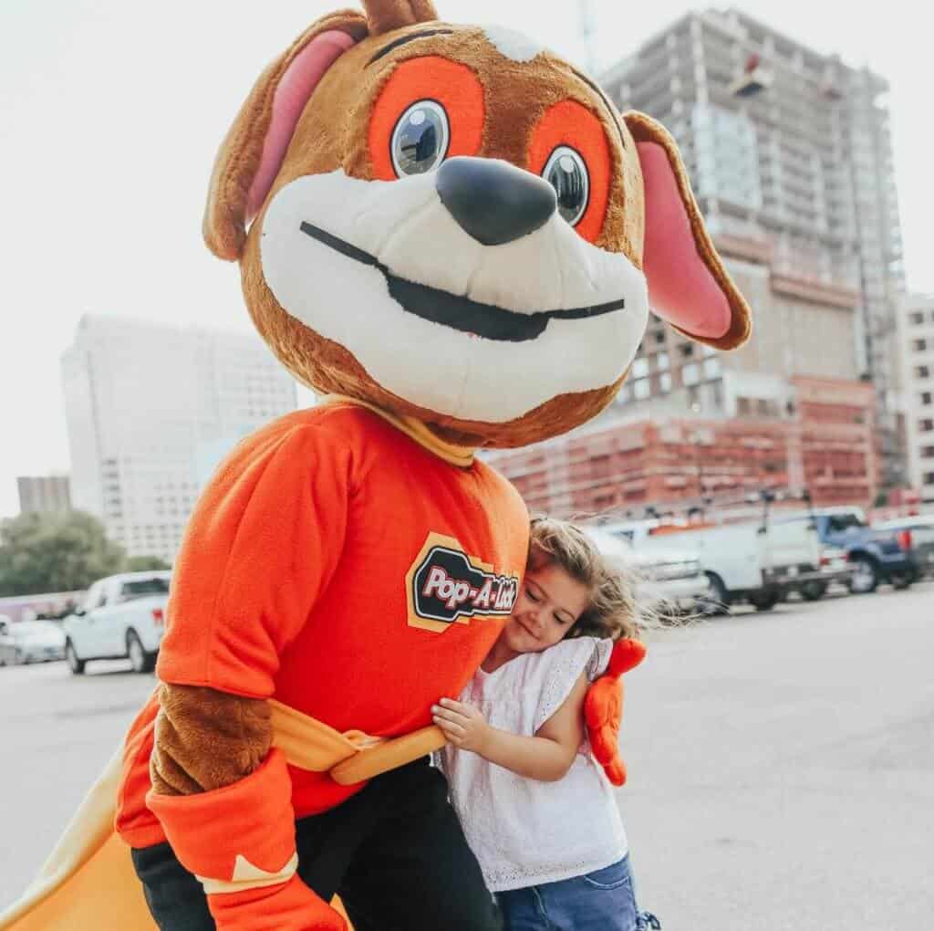 Pop-A-Lock Mascot Hugging Child