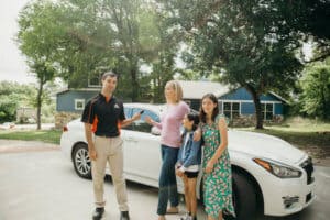 Pop-A-Lock Technician helping family get into white sedan