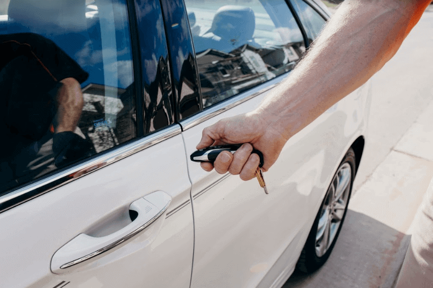 man unlocking car with key fob