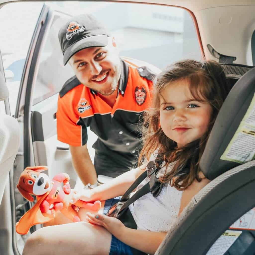 kidincar Pop-A-Lock Technician Opening Door for Child in Car