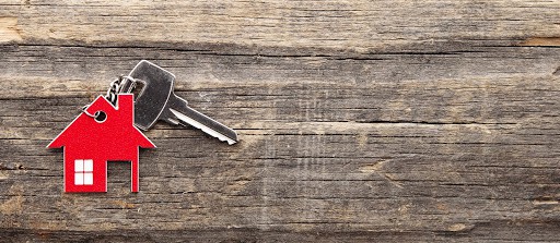Symbol of the house with silver key on vintage wooden background house key