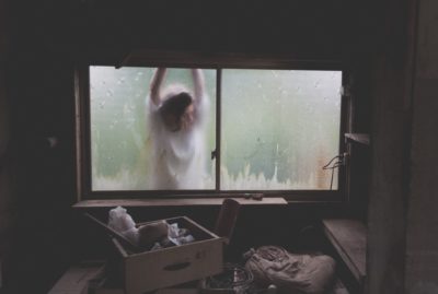 A person looking through a closed window.