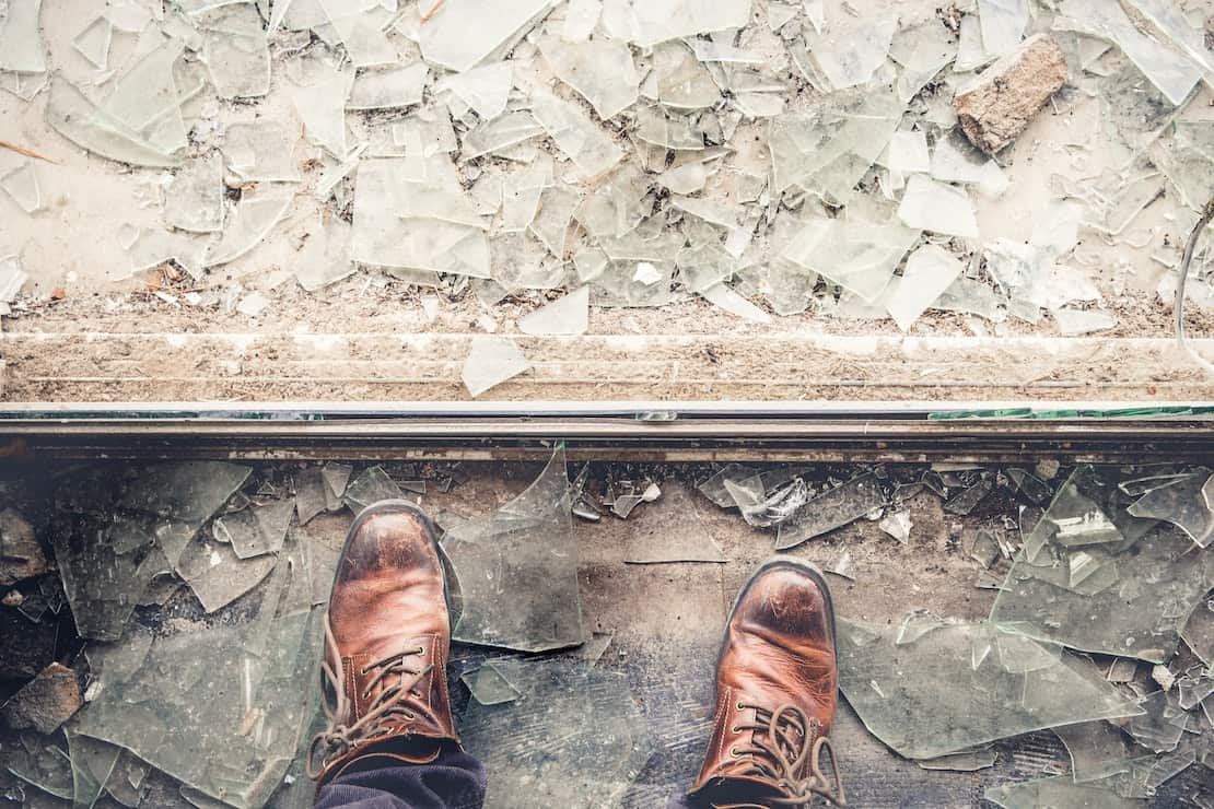 Shattered glass next to a person's feet.