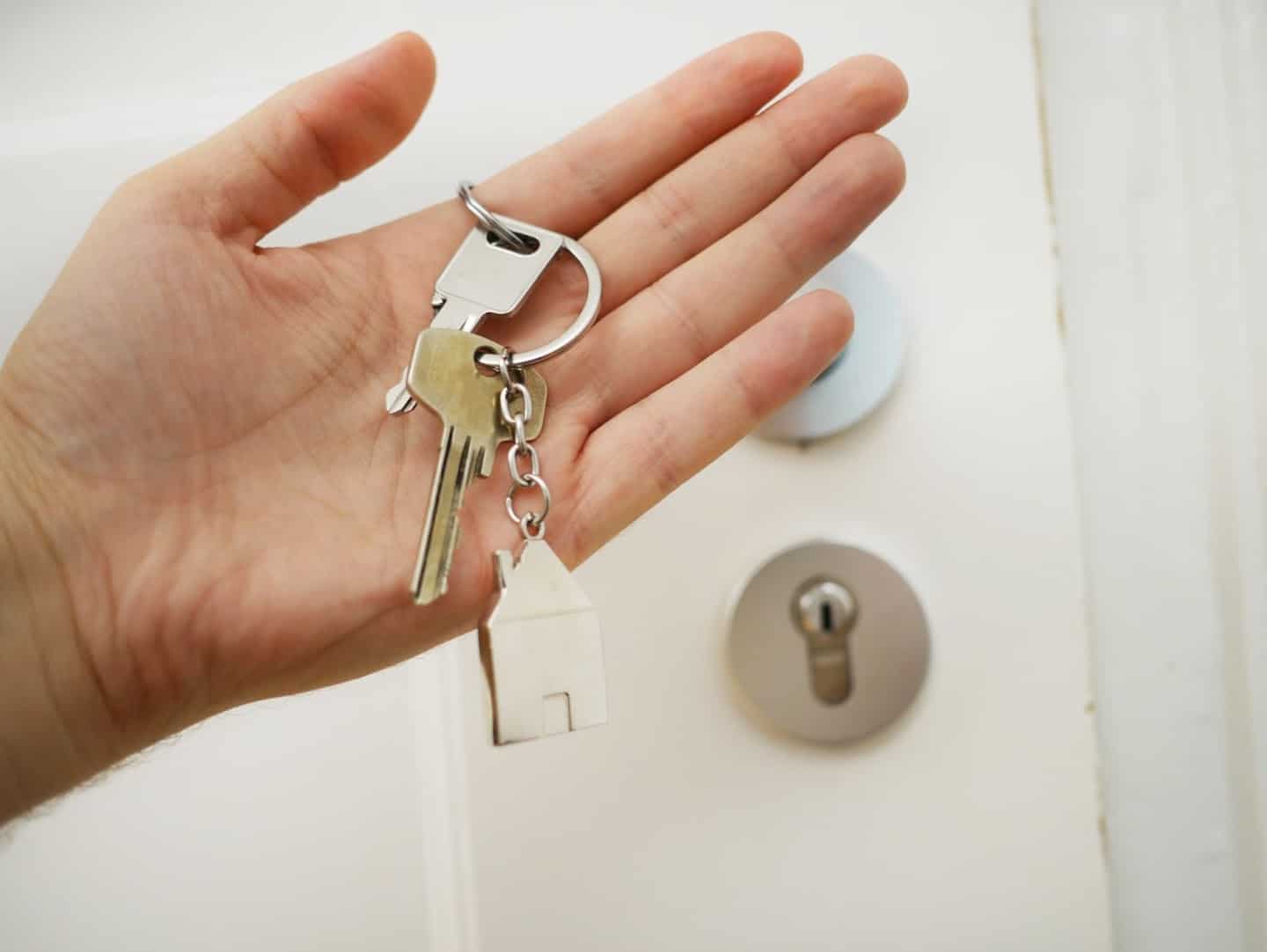 A hand with a keyring around the index finger.