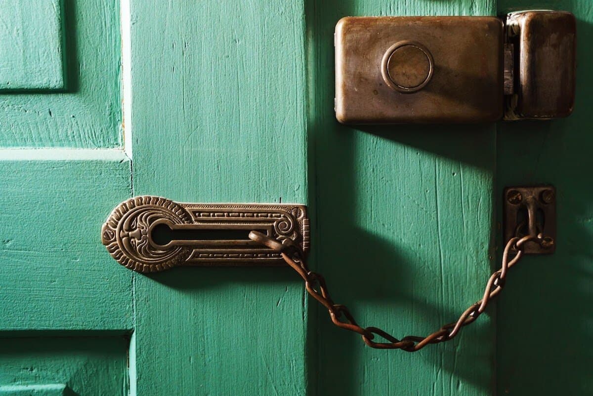 Decorative brass deadbolt on a green door.
