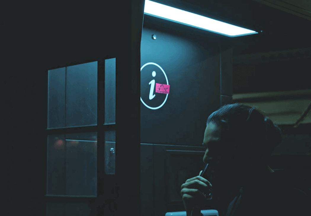 Person standing near an information desk at night.