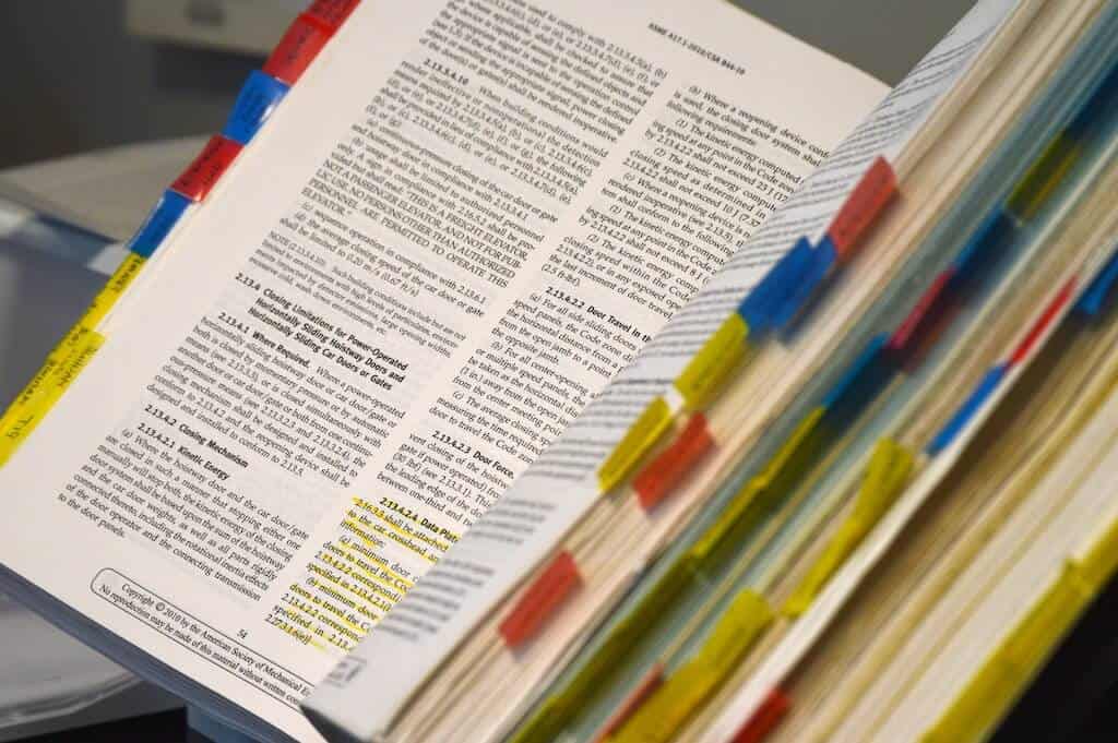 An open book with sticky note tabs sticking off the pages.