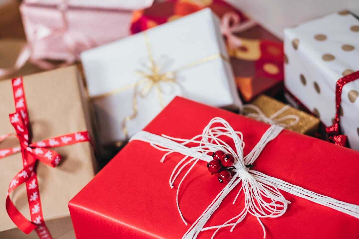 Several wrapped gift boxes in red, white, and brown wrapping paper and ribbons.