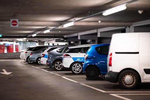 Several cars parked in a row in a parking garage.