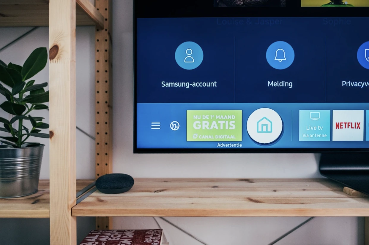 A smart TV on a wooden TV stand.