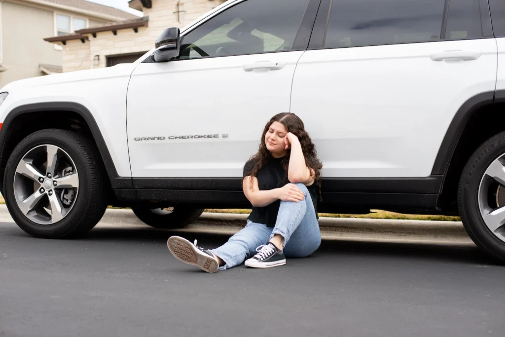 Person sitting outside of their car waiting for a car locksmith in Leeward Oahu to help them regain access to their vehicle.