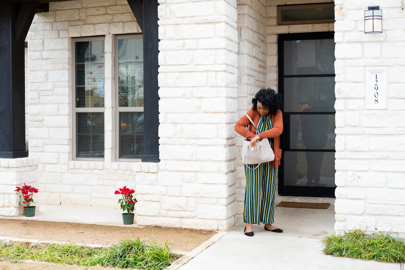 Woman reaching into her purse to find her house keys because she is locked out.