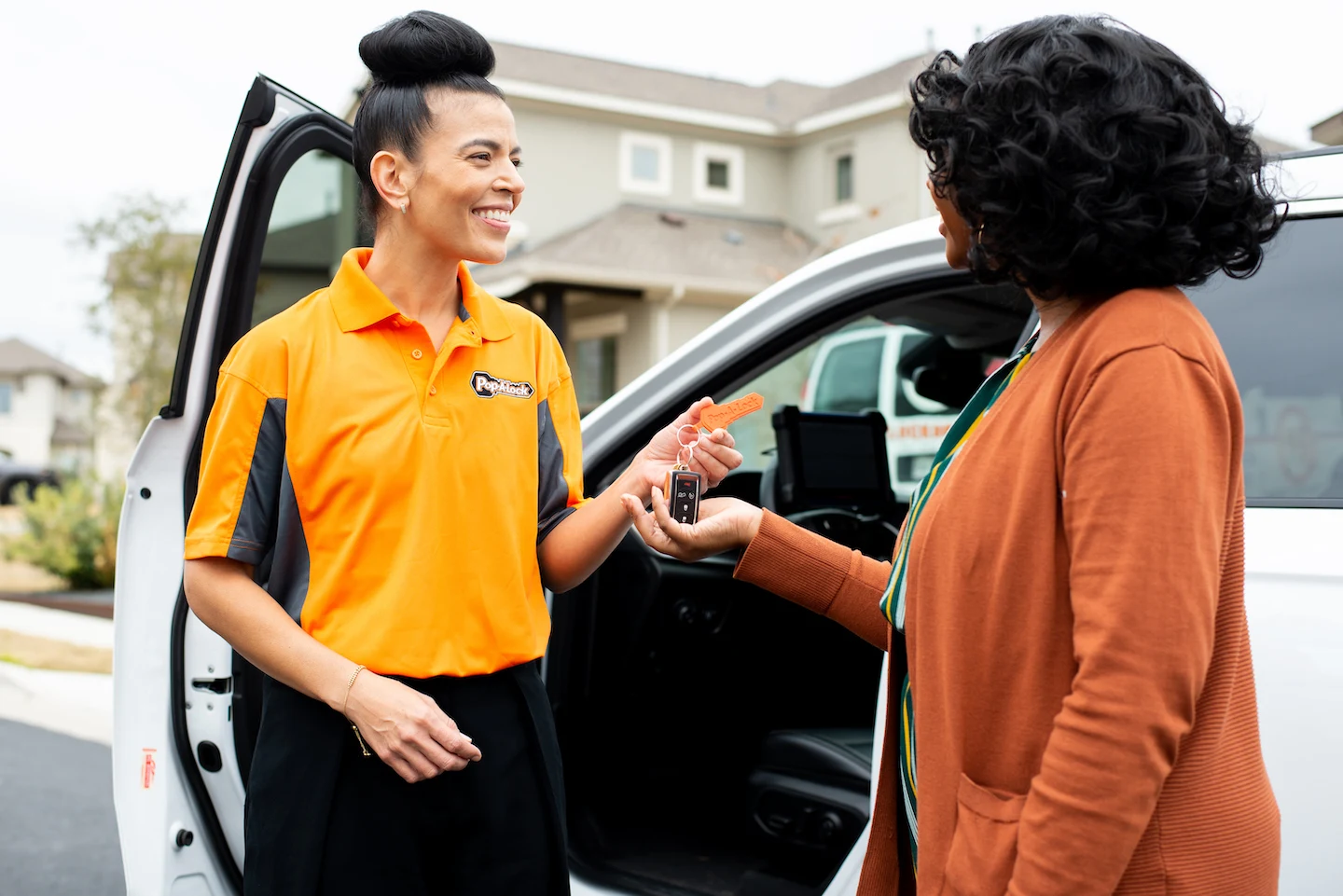 Pop-A-Lock technician handing newly cut car keys to a customer in Lafayette.