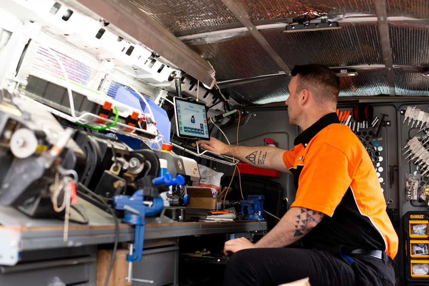 Auto locksmith creating key copy inside Pop-A-Lock van.