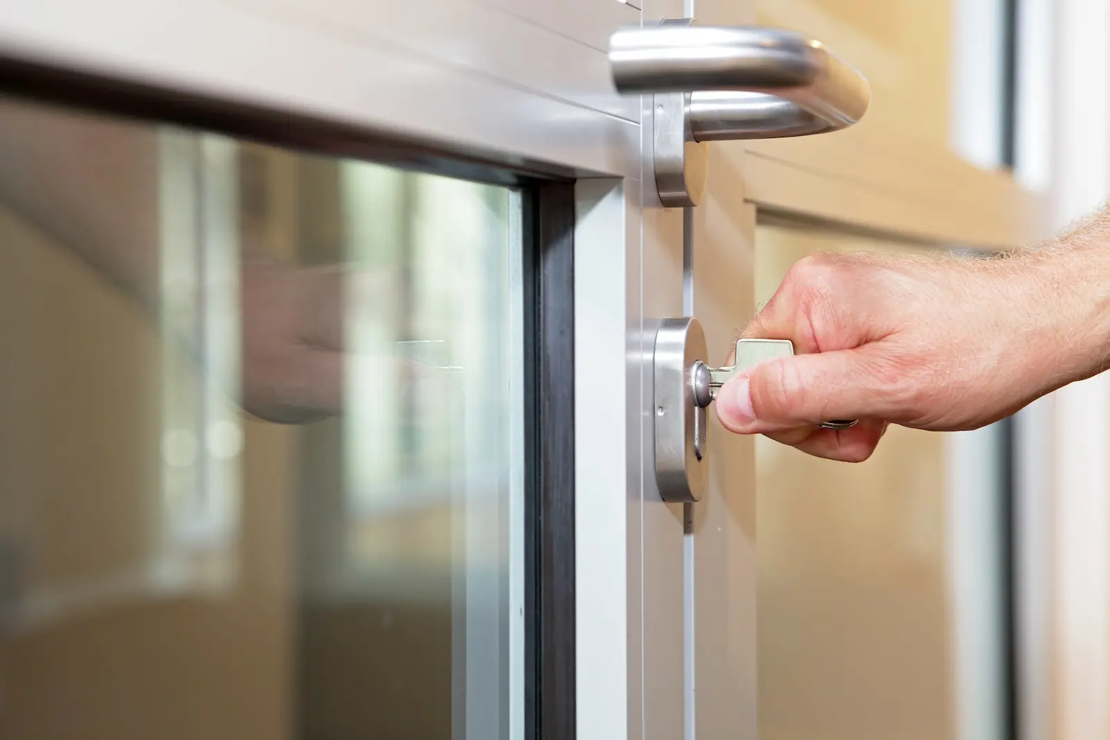 Office building manager turning key in broken door.