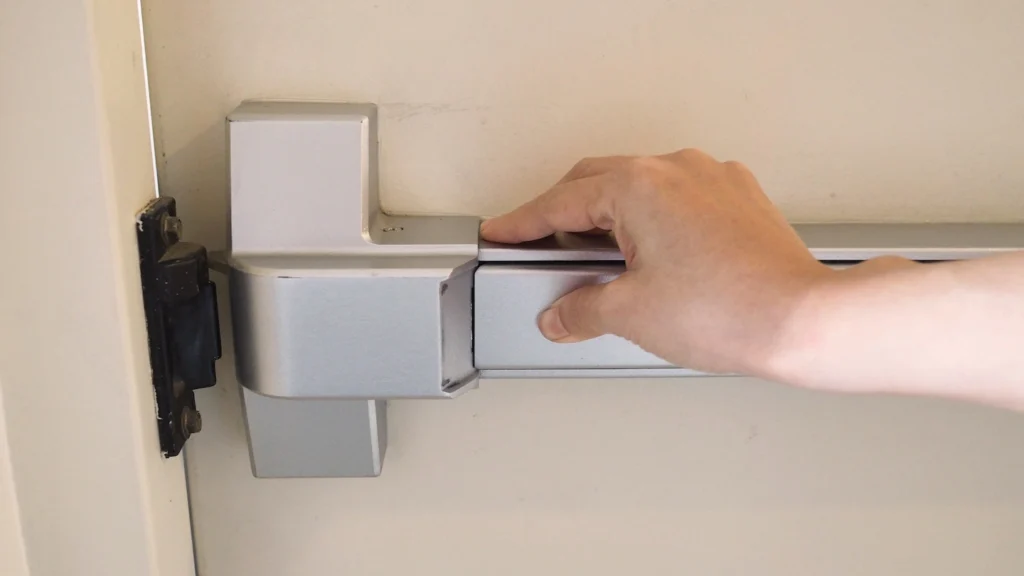 Person pressing on door handle to exit building.