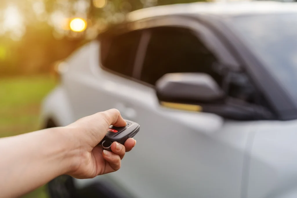 Car owner clicking unlock button on transponder car key.