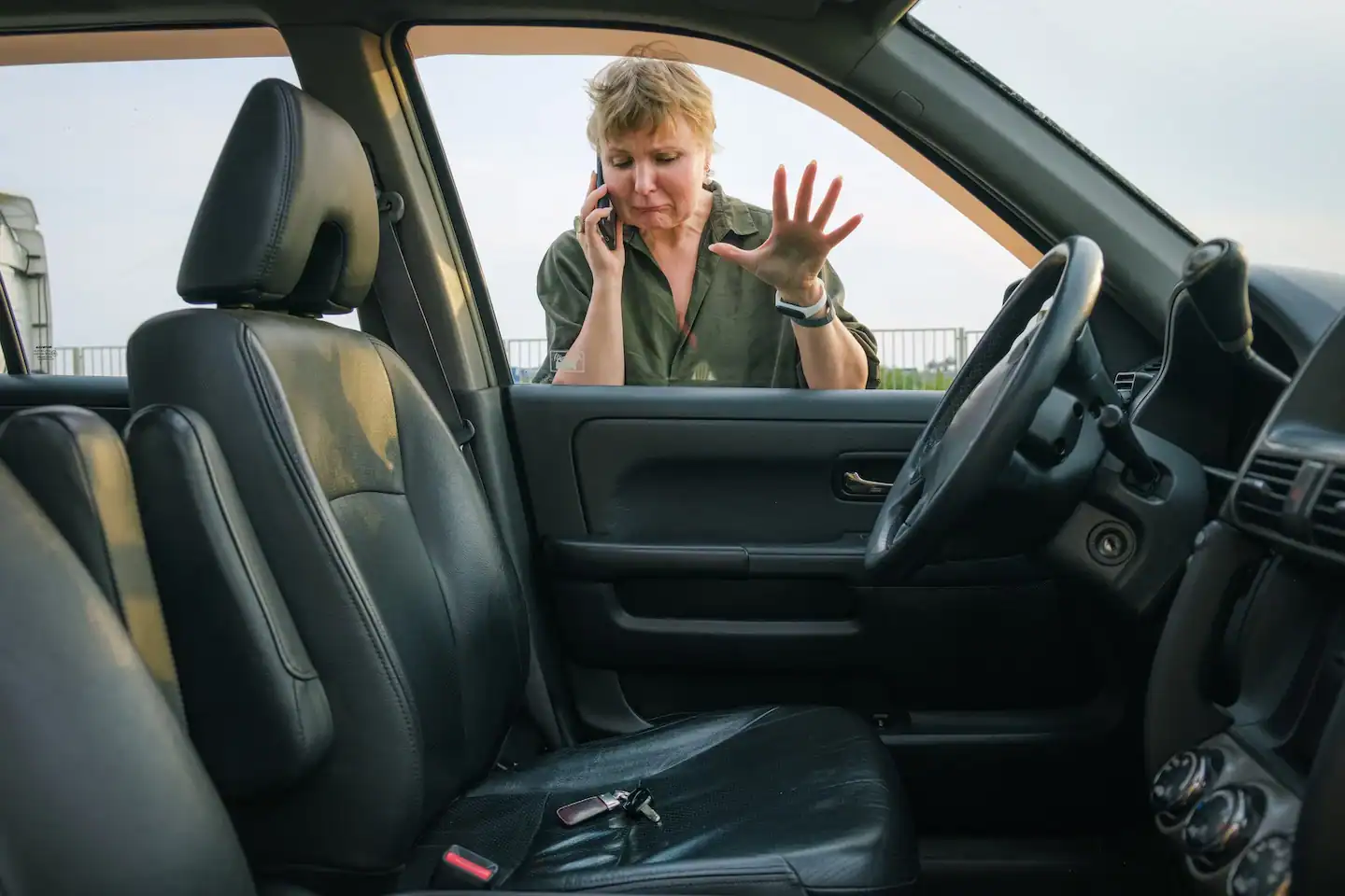 A woman calls an emergency locksmith for help while her keys are locked in her car.
