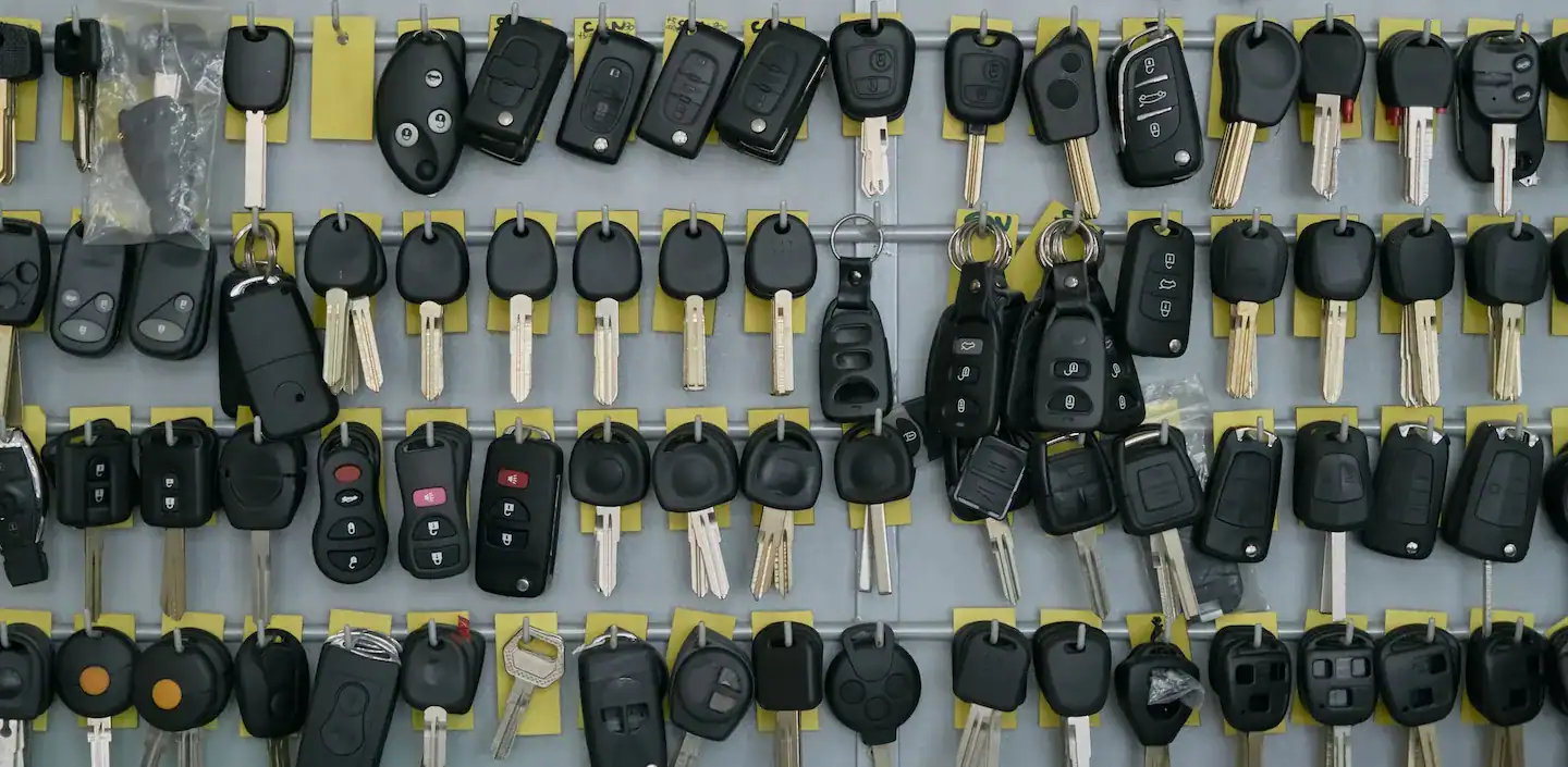 Duplicates of various car keys displayed on a locksmiths wall.
