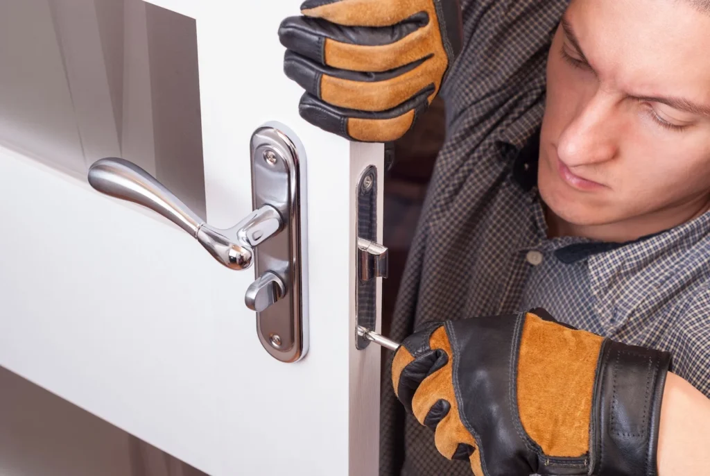 A locksmith installing a door lock handle on a residential door.